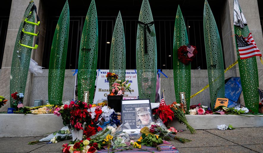 A makeshift memorial for U.S. Army Spc. Sarah Beckstrom and U.S. Air Force Staff Sgt. Andrew Wolfe is seen outside of Farragut West Station, near the site where the two National Guard members were shot, Monday, Dec. 1, 2025, in Washington. (AP Photo/Julia Demaree Nikhinson)