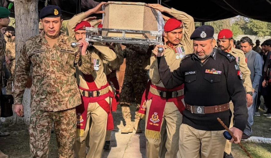Army troops and a police officer carry the casket of a government administrator, who was killed by suspected militants, during his funeral prayer, in Bannu, Pakistan, Tuesday, Dec. 2, 2025. (AP Photo/Ammad Ehsan)