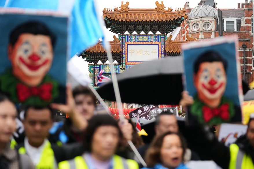 Protesters hold umbrellas, placards, and flags as they demonstrate against the proposed building of a new Chinese embassy, and to mark the 11th year of the Umbrella Revolution in Hong Kong, in London, Sept. 28, 2025. (AP Photo/Joanna Chan, File)
