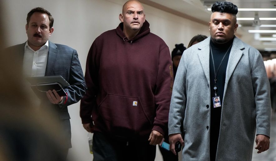 Injuries from a fall are seen on the face of Sen. John Fetterman, D-Pa., second from left, as he walks through a hallway on Capitol Hill, Wednesday, Nov. 19, 2025, in Washington. (AP Photo/Julia Demaree Nikhinson)