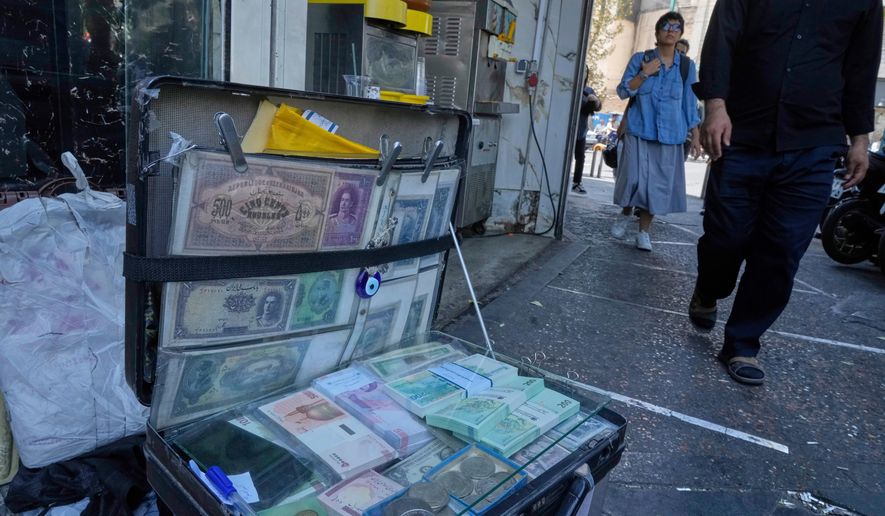 Current and pre-revolution Iranian banknotes are displayed by a street money exchanger at Ferdowsi square, Tehran's go-to venue for foreign currency exchange, in downtown Tehran, Iran, Aug. 28, 2025. (AP Photo/Vahid Salemi, File)