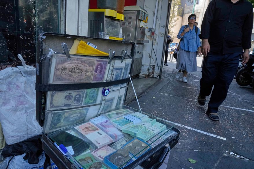 Current and pre-revolution Iranian banknotes are displayed by a street money exchanger at Ferdowsi square, Tehran's go-to venue for foreign currency exchange, in downtown Tehran, Iran, Aug. 28, 2025. (AP Photo/Vahid Salemi, File)