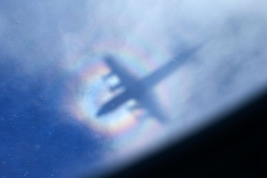 The shadow of a Royal New Zealand Air Force P3 Orion is seen on low level cloud while the aircraft searches for missing Malaysia Airlines Flight MH370 in the southern Indian Ocean, near the coast of Western Australia, March 31, 2014. (AP Photo/Rob Griffith, File)