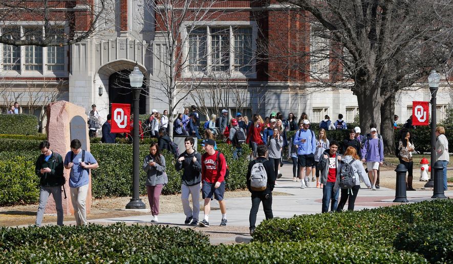 People walk on the Oval at the University of Oklahoma in Norman, Okla., Tuesday, March 10, 2015. (AP Photo/Sue Ogrocki, File)