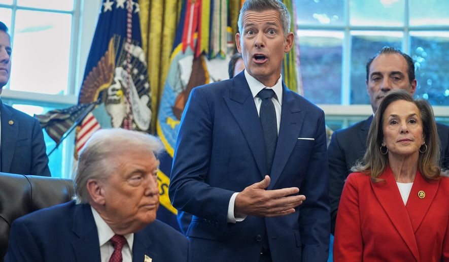 Transportation Secretary Sean Duffy speaks as President Donald Trump looks on, during an event on fuel economy standards in the Oval Office of the White House, Wednesday, Dec. 3, 2025, in Washington. (AP Photo/Evan Vucci)
