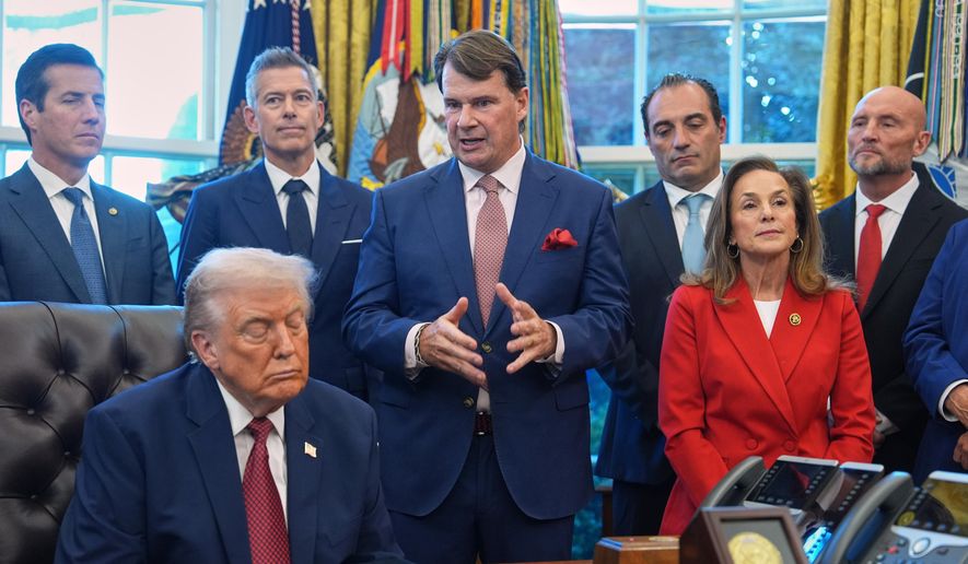 Ford President Jim Farley speaks as President Donald Trump looks on, during an event on fuel economy standards in the Oval Office of the White House, Wednesday, Dec. 3, 2025, in Washington. (AP Photo/Evan Vucci)