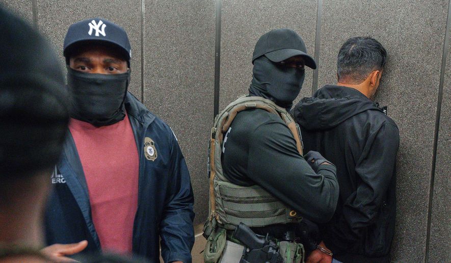 U.S. Immigration and Customs Enforcement agents escort a detained immigrant into an elevator after he exited an immigration courtroom, June 17, 2025, in New York. (AP Photo/Olga Fedorova, File)