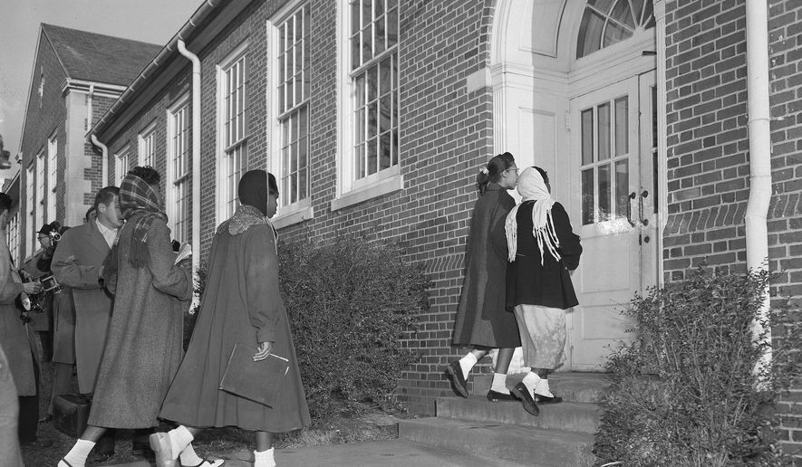 Four unidentified African-American girls return to integrated classes at Clinton High School in Clinton, Tenn., after the school reopened, Dec. 10, 1956. Four African-American boys followed. Renewed violence had closed the school, but the reopening on a continued integrated basis today was without incident. (AP Photo/H.B. Littell)