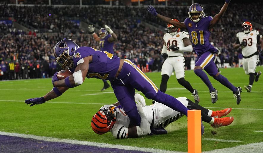 Baltimore Ravens running back Derrick Henry (22) scores a touchdown past Cincinnati Bengals linebacker Demetrius Knight Jr. (44) as Baltimore Ravens wide receiver Devontez Walker (81) celebrates during the first half of an NFL football game, Thursday, Nov. 27, 2025, in Baltimore. (AP Photo/Stephanie Scarbrough)