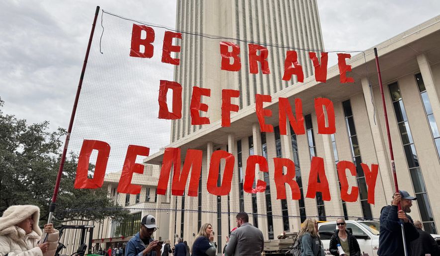 Protestors opposed to mid-decade redistricting hold a sign outside of the Florida Capitol in Tallahassee, Fla. on Dec. 4, 2025. (AP Photo/Kate Payne)