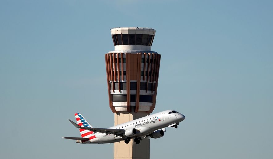 FILE - An American Airlines American Eagle jet flies past the air traffic control tower at Phoenix Sky Harbor International Airport, Nov. 8, 2025, in Phoenix. (AP Photo/Ross D. Franklin, file)