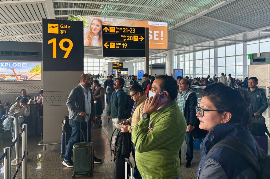 Passengers wait outside the Indira Gandhi International Airport in New Delhi, India, as several Indigo Airlines flights were either cancelled or delayed, Thursday, Dec. 4, 2025. (AP Photo/Manish Swarup)