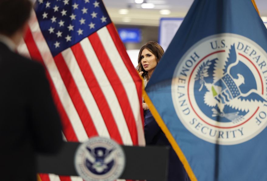 U.S. Homeland Security Secretary Kristi Noem stands near flags after speaking in a news conference at Harry Reid International Airport, Saturday, Nov. 22, 2025, in Las Vegas. (AP Photo/Ronda Churchill)