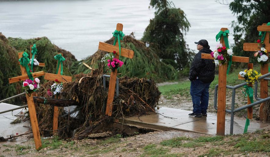 Rain falls as Irene Valdez visits a make-shift memorial for flood victims along the Guadalupe River, Sunday, July 13, 2025, in Kerrville, Texas. (AP Photo/Eric Gay, File)