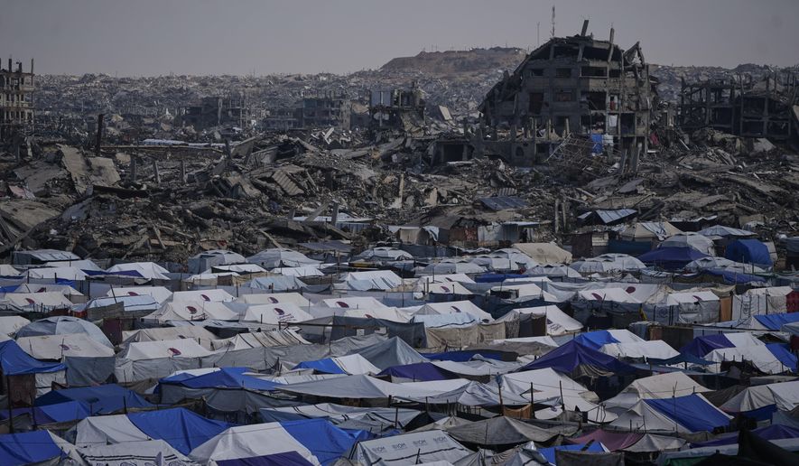 Tents sheltering displaced Palestinians stand amid the destruction left by the Israeli air and ground offensive in Gaza City Friday, Dec. 5, 2025. (AP Photo/Abdel Kareem Hana)