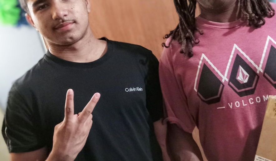 This undated photo provided by Trial Lawyers for Justice shows Konoa Wilson, left, posing with his father, Steven Lee Wilson. (Trial Lawyers for Justice via AP)