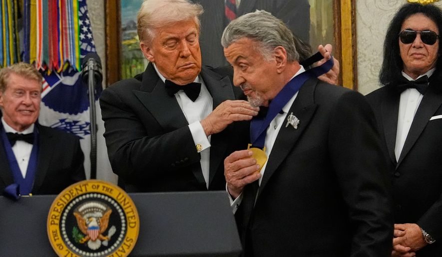 President Donald Trump, left, presents Sylvester Stallone with his Kennedy Center Honors medal in the Oval Office of the White House, Saturday, Dec. 6, 2025, in Washington. (AP Photo/Julia Demaree Nikhinson)