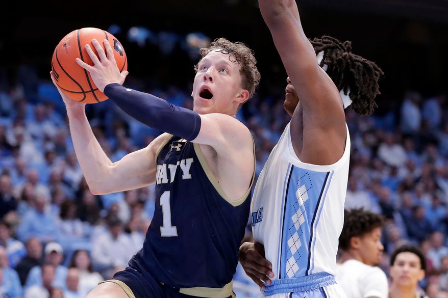 Navy guard Austin Benigni (1) drives against North Carolina forward James Brown, right, during the second half of an NCAA college basketball game, Tuesday, Nov. 18, 2025, in Chapel Hill, N.C. (AP Photo/Chris Seward) **FILE**