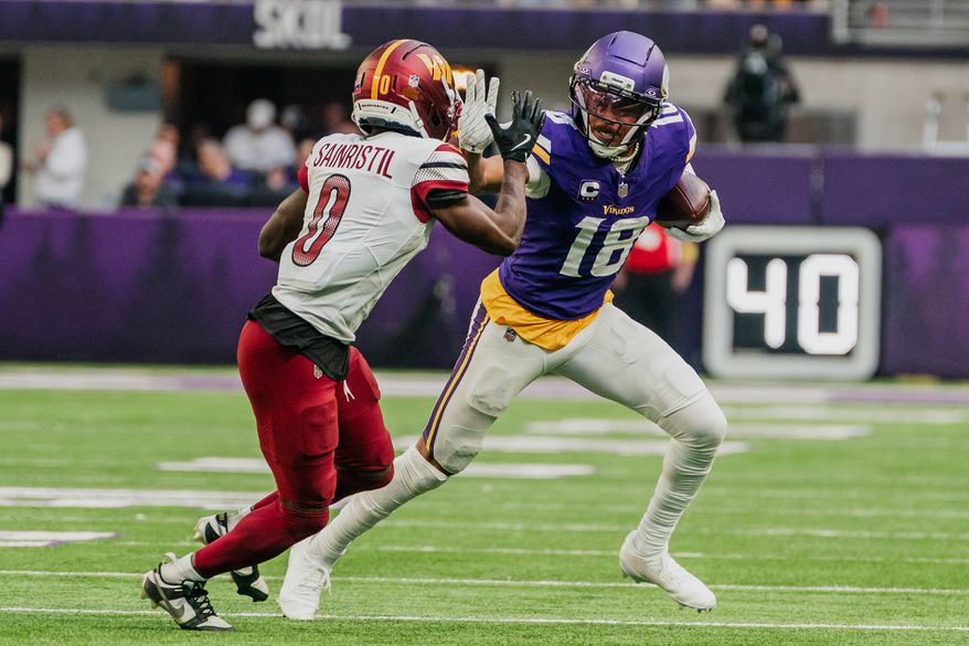 Minnesota Vikings Wide Receiver Justin Jefferson (18) stiff arms Washington Commander Defensive Back Mikey Sainristil (0) at U.S. Bank Stadium in Minneapolis, Minnesota. The Minnesota Vikings defeated the Washington Commanders 31-0 during NFL Week 14 on December 7th, 2025. (Photo by Jordan Sabillo for Washington Times)