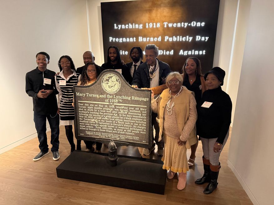 Descendants of Mary Turner, who was lynched in 1918, pose with her historic marker and artist Lonnie Holley, fourth from left, at the National Center for Civil and Human Rights, on Dec. 6, 2025 in Atlanta. (AP Photo/Michael Warren)