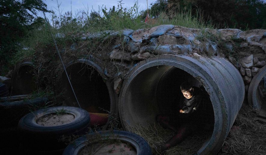 A Thai resident who fled clashes between Thai and Cambodian soldiers, uses mobile phone while taking shelter in Buriram province, Thailand, Tuesday, Dec. 9, 2025. (AP Photo/Wason Wanichakorn)