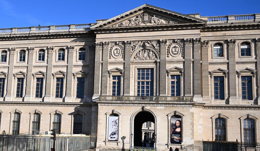 People walk by an entrance of the Louvre museum, Thursday, Oct. 30, 2025 in Paris. (AP Photo/Emma Da Silva, file)
