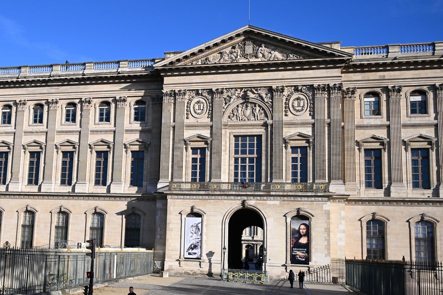 People walk by an entrance of the Louvre museum, Thursday, Oct. 30, 2025 in Paris. (AP Photo/Emma Da Silva, file)