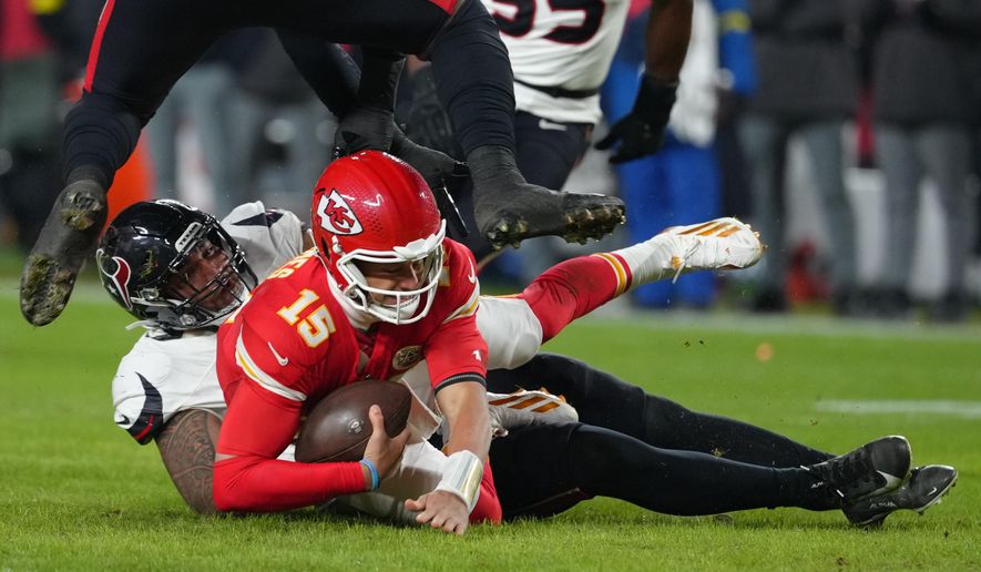 Kansas City Chiefs quarterback Patrick Mahomes (15) is sacked by Houston Texans defensive tackle Tommy Togiai during the first half of an NFL football game Sunday, Dec. 7, 2025, in Kansas City, Mo. (AP Photo/Ed Zurga)