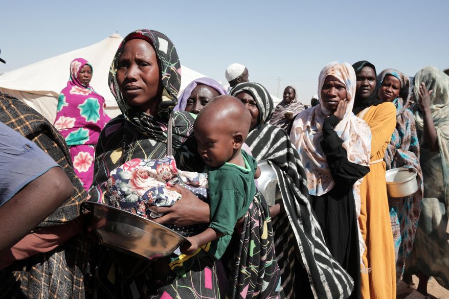 Women displaced from El-Fasher stand in line to receive food aid at the newly established El-Afadh camp in Al Dabbah, in Sudan's Northern State, Nov. 16, 2025. (AP Photo/Marwan Ali, File)