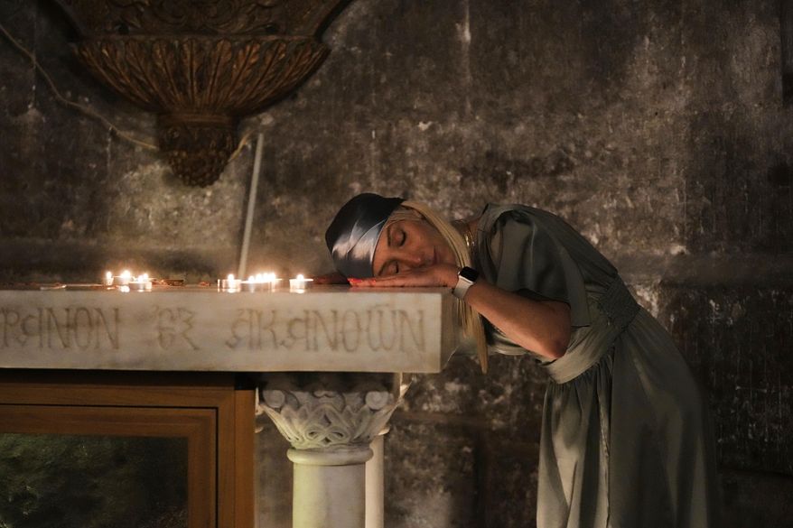 A Christian pilgrim rests her head while praying during Easter Sunday Mass at the Church of the Holy Sepulcher, the site where according to tradition Jesus was crucified and buried, in Jerusalem's Old City, April 20, 2025. (AP Photo/Mahmoud Illean, File)