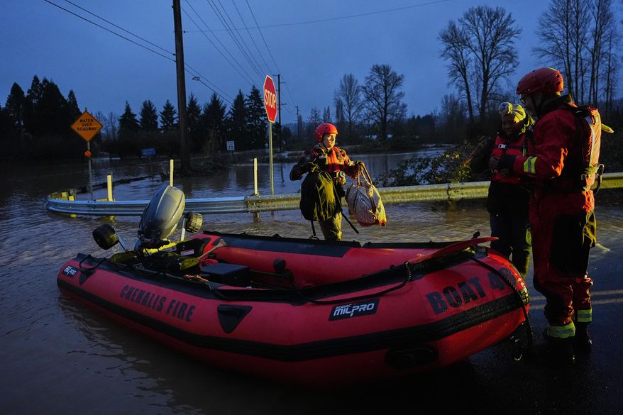 Chehalis Fire rescue workers help residents evacuate their flooded neighborhood after heavy rains in the region Tuesday, Dec. 9, 2025, in Chehalis, Wash. (AP Photo/Lindsey Wasson)
