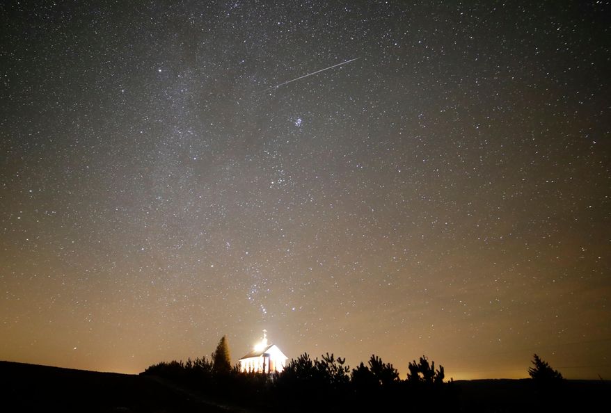 FILE - A meteor streaks over an Orthodox church during the annual Geminid meteor shower near the village of Zagorie, some 110 kms. (69 miles) west of Minsk, Belarus, Dec. 13, 2017. (AP Photo/Sergei Grits, File)