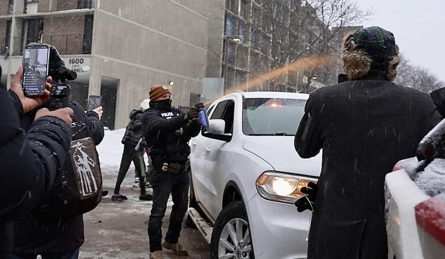 Activists confronted a group of Immigration and Customs Enforcement officers in the largely Somali neighborhood of Cedar-Riverside in Minneapolis, Tuesday, Dec. 9, 2025. (AP Photo/Mark Vancleave)