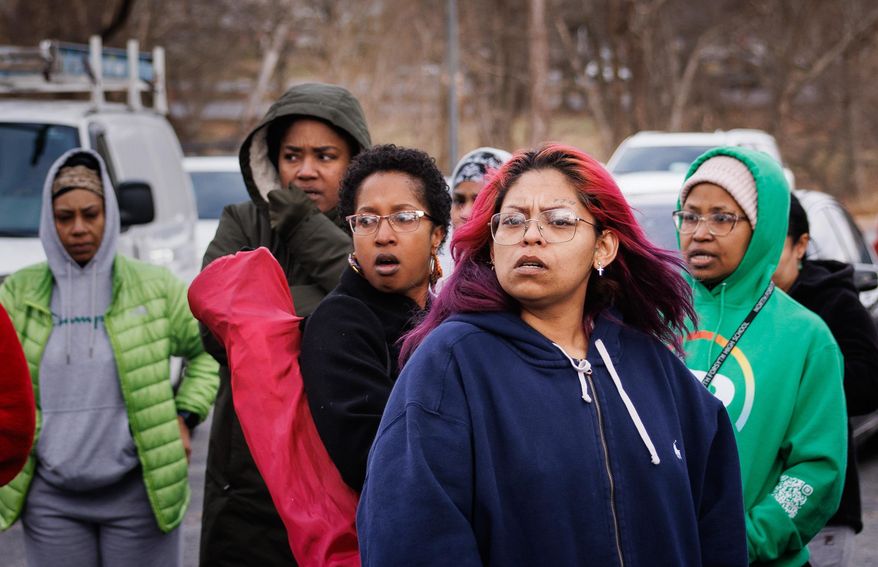 Family members and friends of North Forsyth High School students watch and wait in a parking lot across the street from the school after a fatal stabbing , Tuesday, Dec. 9, 2025, in Winston-Salem, N.C. (Allison Lee Isley/The Winston-Salem Journal via AP)