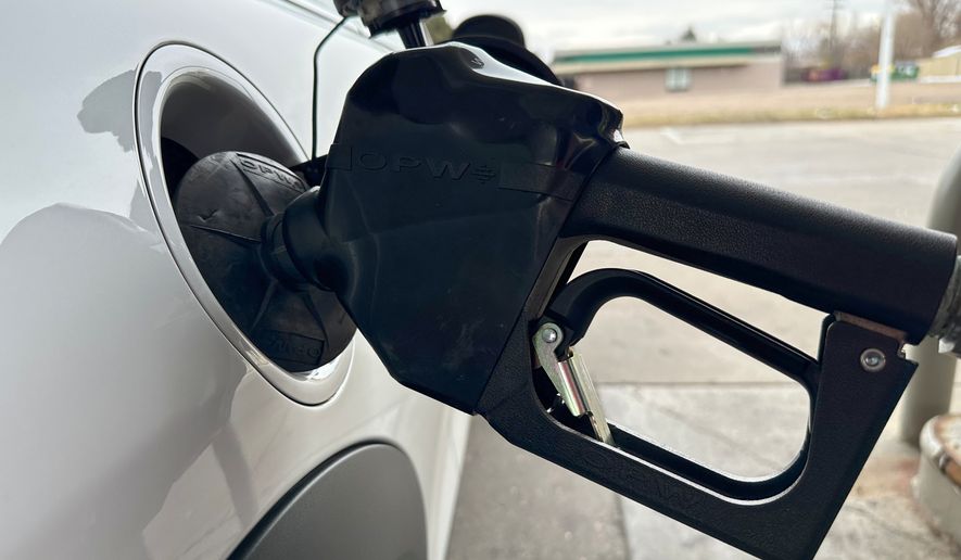 A motorist fills up the tank of a vehicle at an Exxon gasoline station Sunday, Nov. 30, 2025, in Littleton, Colo. (AP Photo/David Zalubowski)