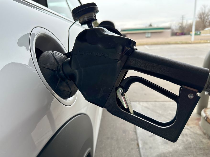 A motorist fills up the tank of a vehicle at an Exxon gasoline station Sunday, Nov. 30, 2025, in Littleton, Colo. (AP Photo/David Zalubowski)