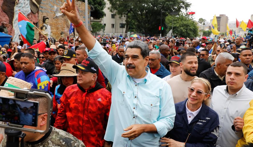 President Nicolas Maduro joins a rally marking the anniversary of the Battle of Santa Isabel, which took place during Venezuela's 19th-century Federal War, in Caracas, Venezuela, Wednesday, Dec. 10, 2025. (AP Photo/Cristian Hernandez)