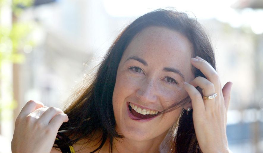 Author Sophie Kinsella poses on Wimbledon Village high street, London, Sept. 9, 2004. (AP Photo/Adam Butle, File)