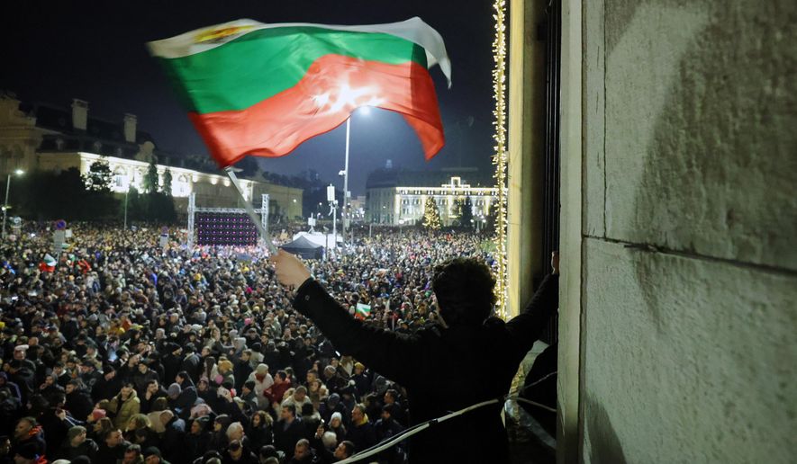 A student waves a Bulgarian flag as a swelling crowd of tens of thousands of Bulgarians filled Sofia's central square, demanding the government's resignation amid rising anger over corruption and contested economic policies, Sofia, Bulgaria, Wednesday, Dec. 10, 2025. (AP Photo/Valentina Petrova)