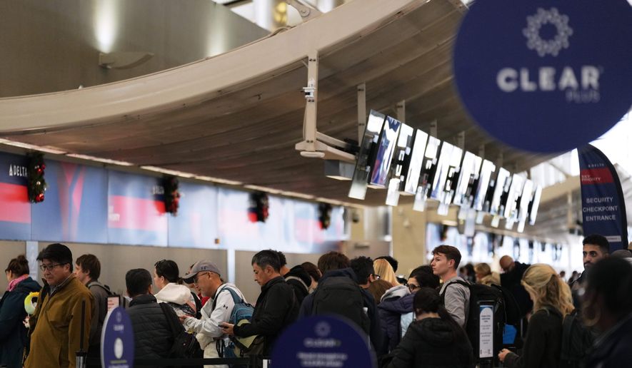 Travelers wait in a TSA checkpoint at Detroit Metropolitan Wayne County Airport Wednesday, Nov. 26, 2025, in Romulus, Mich. (AP Photo/Ryan Sun)