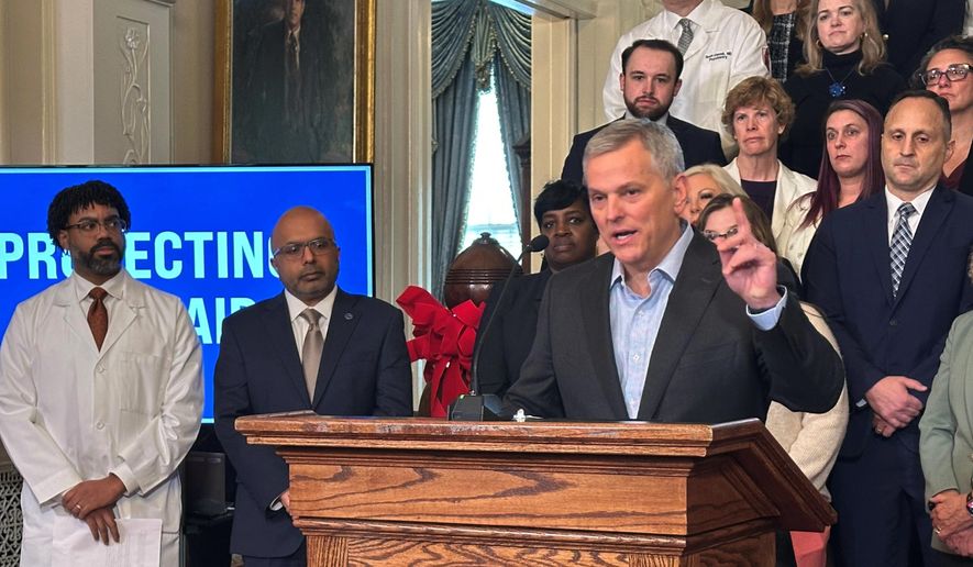 North Carolina Gov. Josh Stein, right, speaks while Dr. Benjamin Simmons with the North Carolina Academy of Family Physicians, far left, and state Health and Human Services Secretary Dr. Dev Sangvai listen to Stein discussing the restoration of Medicaid reimbursement rates to pre-October levels at an Executive Mansion news conference on Wednesday, Dec. 10, 2025 in Raleigh, N.C. (AP Photo/Gary D. Robertson)