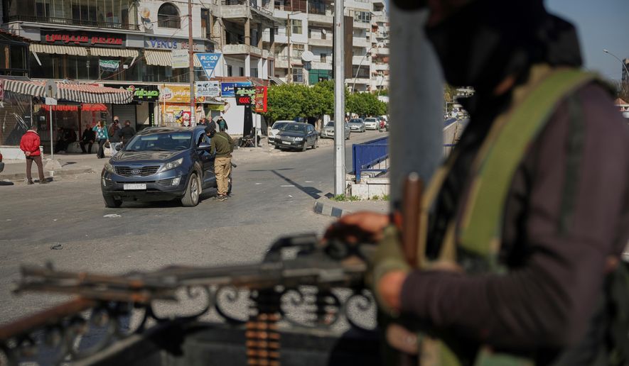 Syrian security forces inspect vehicles at a checkpoint, following a recent wave of violence between Syrian security forces and gunmen loyal to former President Bashar Assad, as well as subsequent sectarian attacks, in Latakia, in Syria's coastal region, March 11, 2025. (AP Photo/Ghaith Alsayed, File)