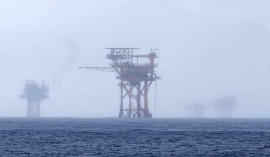 FILE - Oil platforms are visible through the haze near the Flower Garden Banks National Marine Sanctuary in the Gulf of Mexico, off the coast of Galveston, Texas, Saturday, Sept. 16, 2023. (AP Photo/LM Otero, File)