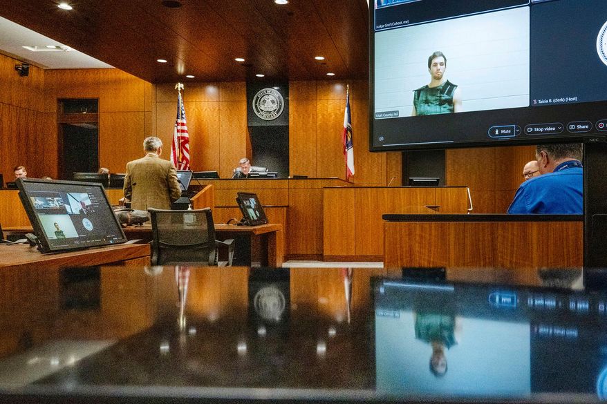 Defense attorney Greg Skordas, left, speaks before Judge Tony Graf, background, in Provo, Utah, as Tyler Robinson, in monitor at right, accused of fatally shooting Charlie Kirk, attends the court hearing virtually from prison on Tuesday, Sept. 16, 2025. (Scott G Winterton/The Deseret News via AP, Pool, File)