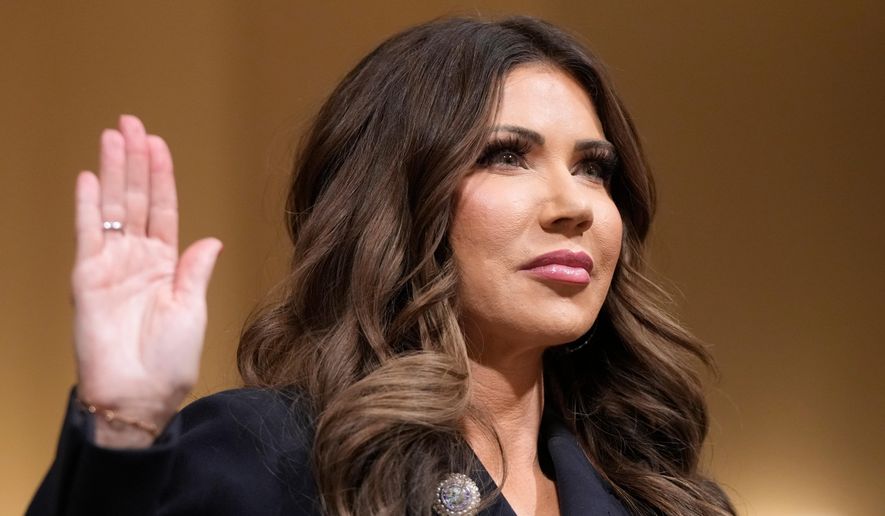 Homeland Security Secretary Kristi Noem raise her arm before the House Committee on Homeland Security on Capitol Hill in Washington, Thursday, Dec. 11, 2025. (AP Photo/Mark Schiefelbein)
