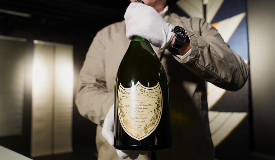 Thomas Rosendahl, head of wine department of Bruun Rasmussen auction house, holds a bottle of Dom Perignon Vintage 1961 champagne, specially produced for wedding of The Prince of Wales and Lady Diana in 1981, in Lyngby, Denmark, Wednesday, Dec. 3, 2025. (AP Photo/James Brooks)