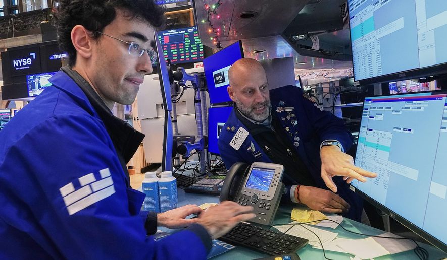 Specialists Alex Weitzman, left, and Meric Greenbaum work on the floor of the New York Stock Exchange, Thursday, Dec. 11, 2025. (AP Photo/Richard Drew)