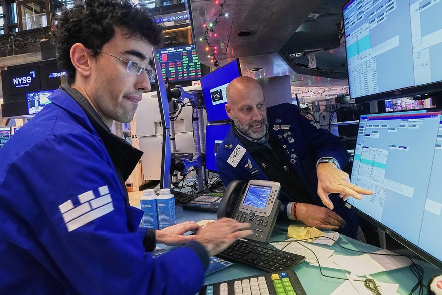 Specialists Alex Weitzman, left, and Meric Greenbaum work on the floor of the New York Stock Exchange, Thursday, Dec. 11, 2025. (AP Photo/Richard Drew)