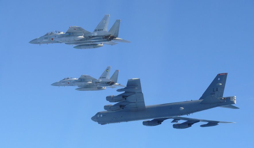 This photo provided by Japan's Ministry of Defense shows the Japan Air Self-Defense Force's F-15 fighters holding a joint military drill with the U.S. B-52 bomber in the vicinity of Japanese airspace on Wednesday Dec. 10, 2025. (Japan's Ministry of Defense via AP)