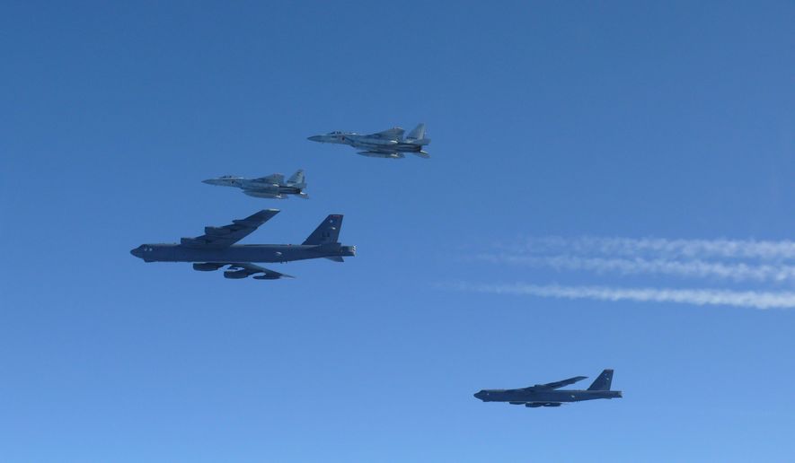 This photo provided by Japan's Ministry of Defense shows the Japan Air Self-Defense Force's F-15 fighters holding a joint military drill with the U.S. B-52 bombers in the vicinity of Japanese airspace on Wednesday Dec. 10, 2025. (Japan's Ministry of Defense via AP)